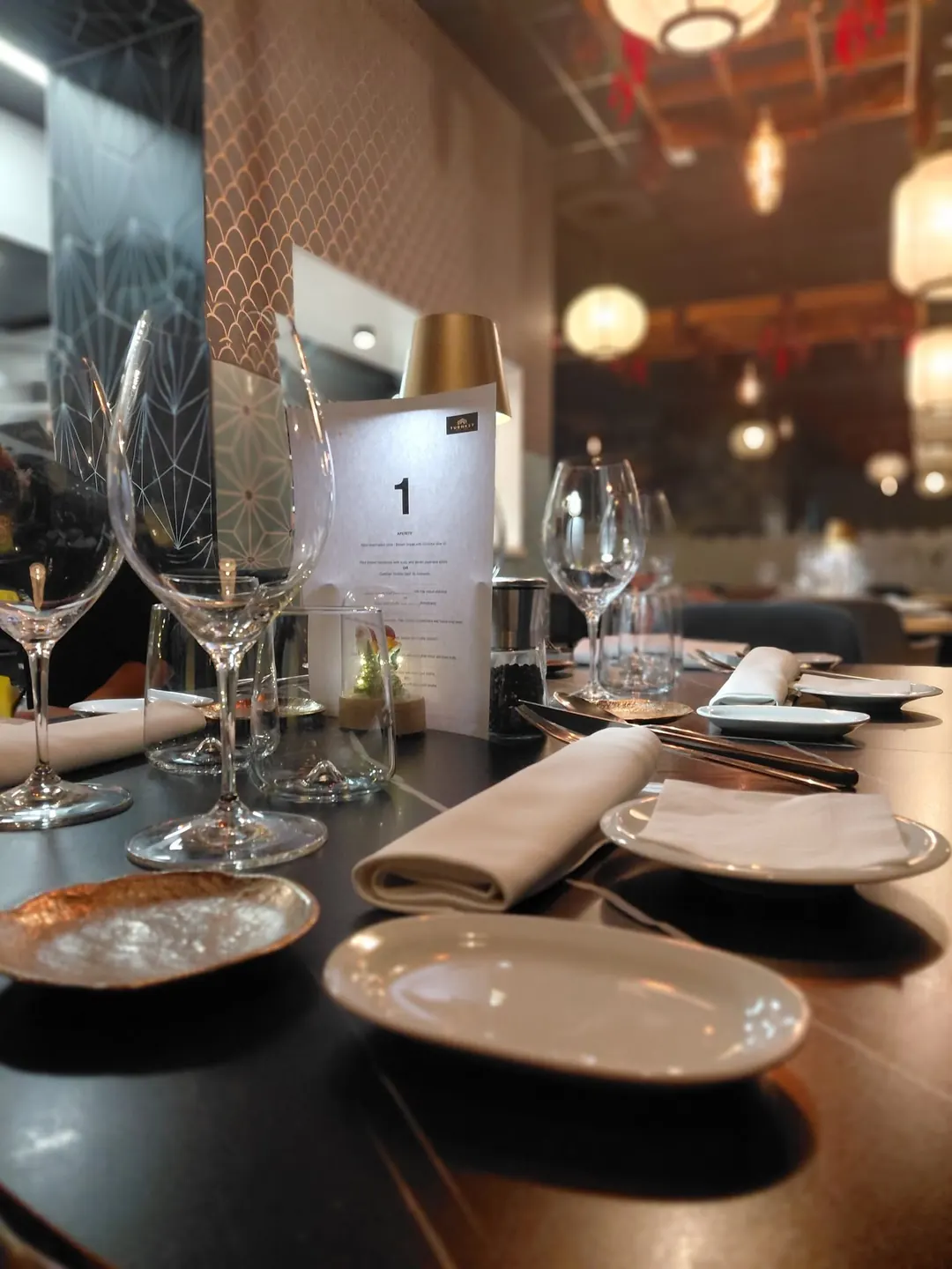 A table laid for the tasting menu, with a numbered course card and wine glasses